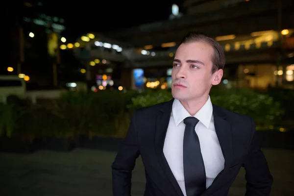 Porträt eines jungen Geschäftsmannes, der nachts im Freien denkt — Stockfoto
