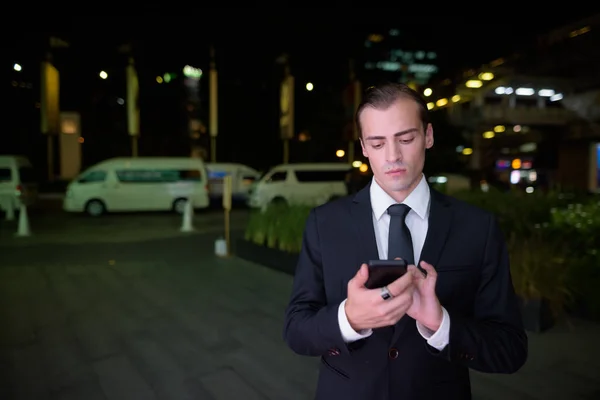 Portrait de jeune homme d'affaires pensant à l'extérieur la nuit — Photo