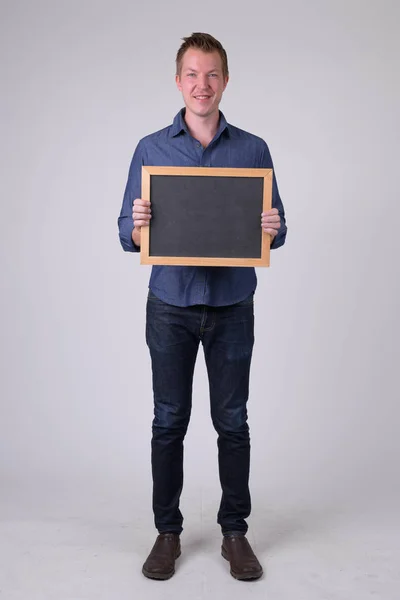 快乐的年轻商人拿着黑板的全身照 — 图库照片