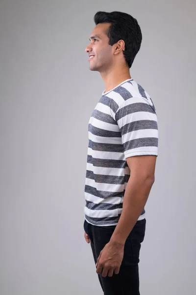 Profile view of happy young handsome Indian man smiling — Stock Photo, Image