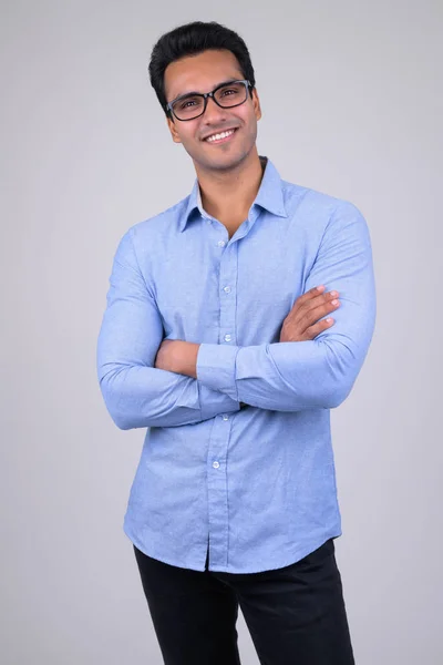 Happy young handsome Indian businessman with eyeglasses crossing arms — Stock Photo, Image