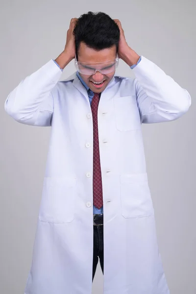 Arrabbiato giovane medico indiano con occhiali protettivi cercando stressato — Foto Stock