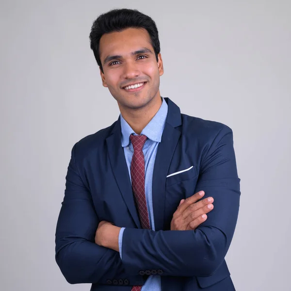 Glücklich junge gut aussehende indische Geschäftsmann lächelt mit verschränkten Armen — Stockfoto