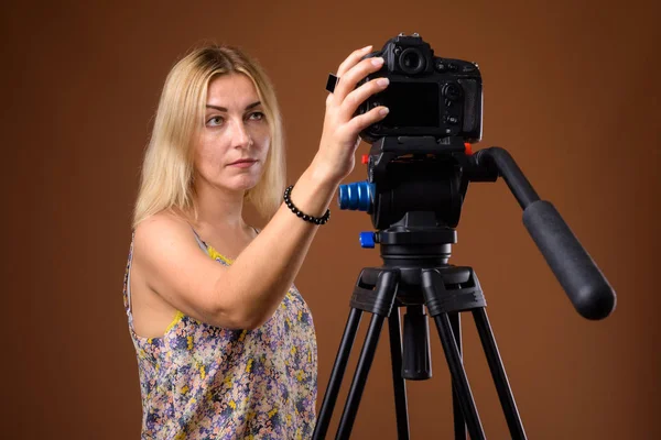 Vrouw fotograaf met Dslr camera in statief in studio — Stockfoto