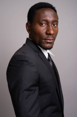 Genç yakışıklı Afrikalı işadamı gri arka planda