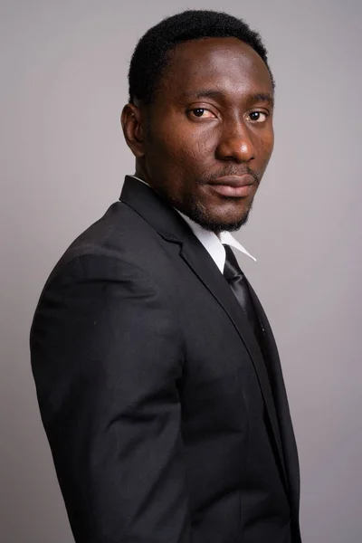 Ung stilig afrikansk affärsman mot grå bakgrund — Stockfoto