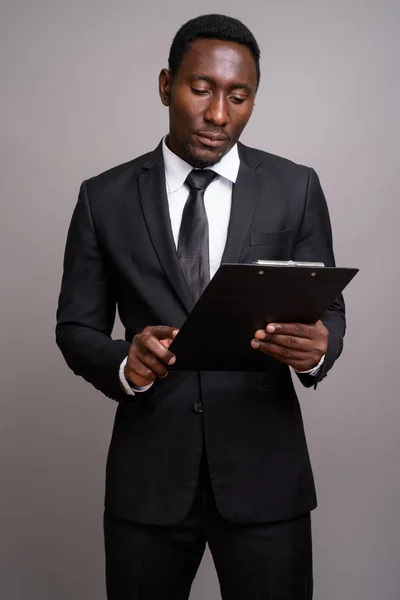 Joven hombre de negocios africano guapo sobre fondo gris —  Fotos de Stock