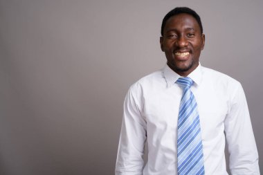 Genç yakışıklı Afrikalı işadamı gri arka planda