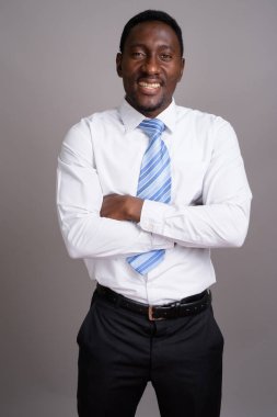 Genç yakışıklı Afrikalı işadamı gri arka planda