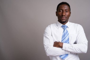Genç yakışıklı Afrikalı işadamı gri arka planda
