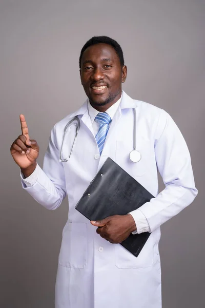 Jovem bonito Africano homem médico contra fundo cinza — Fotografia de Stock
