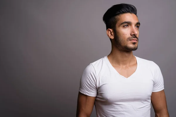 Junger gutaussehender persischer Mann mit grauem Hintergrund — Stockfoto