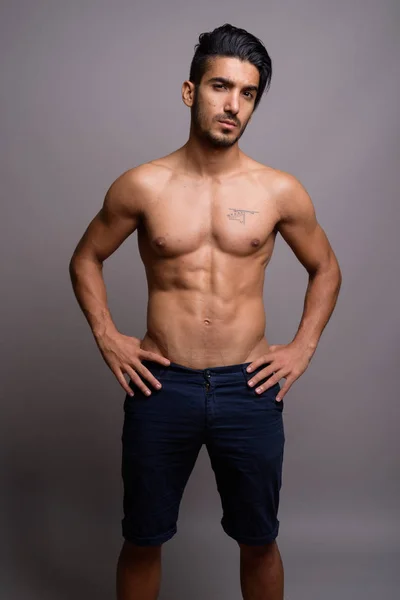 Młody przystojny mężczyzna Perski shirtless szarym tle — Zdjęcie stockowe