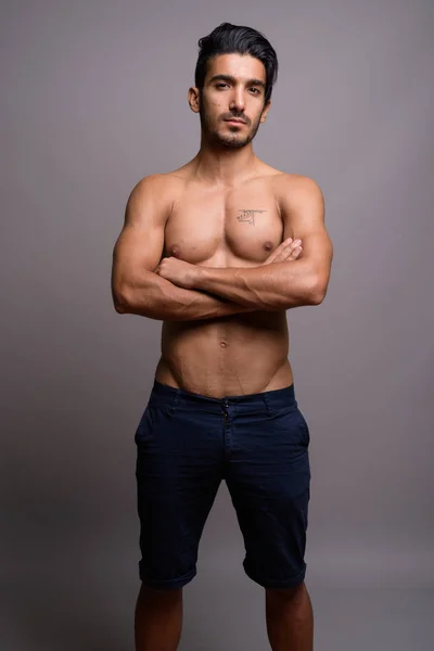 Młody przystojny mężczyzna Perski shirtless szarym tle — Zdjęcie stockowe