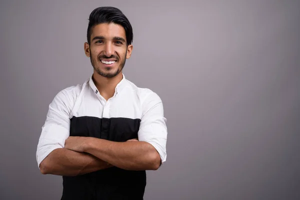 Junger gutaussehender persischer Geschäftsmann vor grauem Hintergrund — Stockfoto