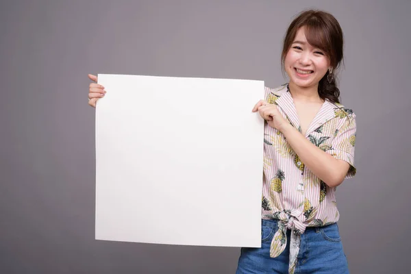 Asijské žena držící prázdná bílá deska s copyspace — Stock fotografie