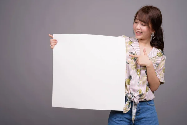 Mujer asiática sosteniendo tablero blanco vacío con copyspace — Foto de Stock