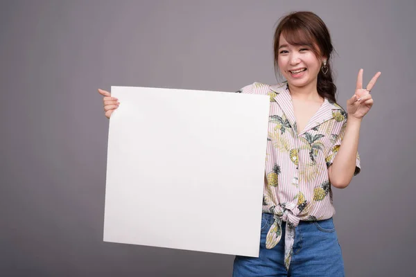 Asiático mulher segurando vazio branco bordo com copyspace — Fotografia de Stock