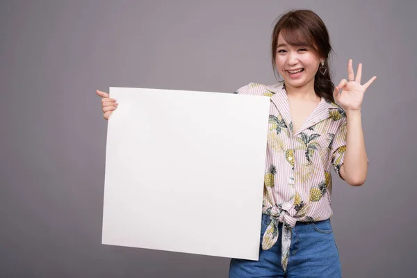 Asiático mulher segurando vazio branco bordo com copyspace — Fotografia de Stock