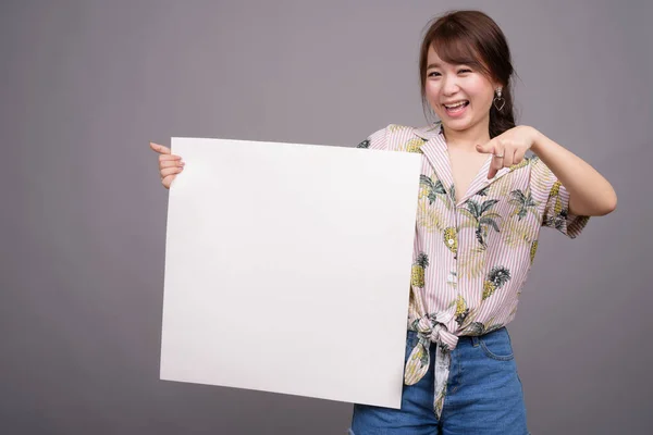 Mujer asiática sosteniendo tablero blanco vacío con copyspace —  Fotos de Stock