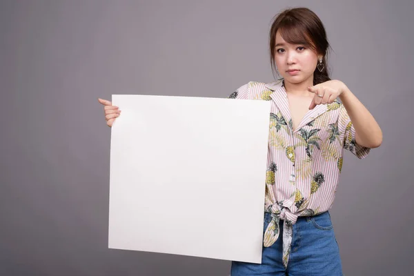 Азиатка держит пустую белую доску с копирайтом — стоковое фото