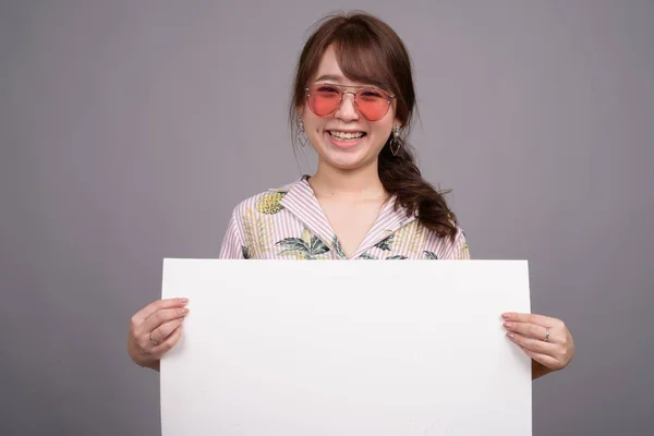 Mujer asiática sosteniendo tablero blanco vacío con copyspace —  Fotos de Stock