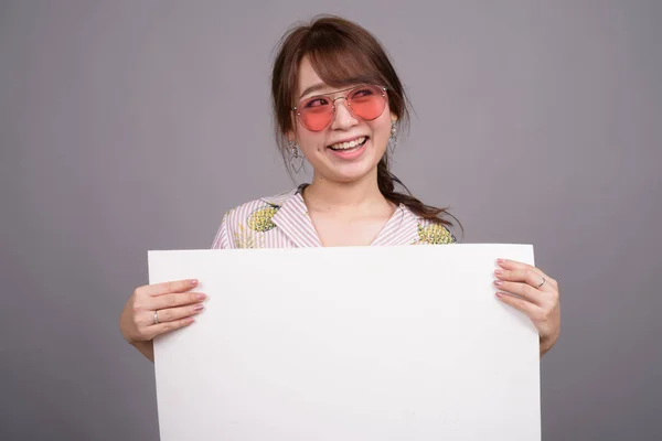 Азиатка держит пустую белую доску с копирайтом — стоковое фото