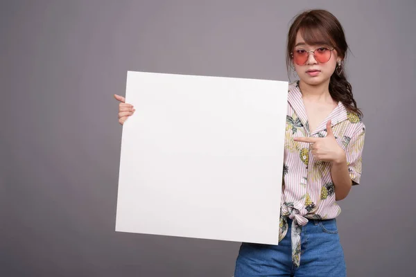 Mujer asiática sosteniendo tablero blanco vacío con copyspace — Foto de Stock