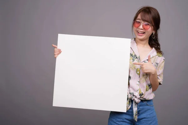 Aziatische vrouw met leeg wit bord met copyspace — Stockfoto