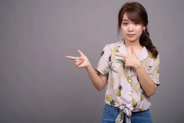 Aziatische toeristische woman wijzend vinger en weergegeven: copyspace — Stockfoto