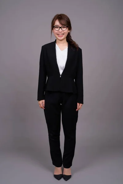 立っている若いアジア女性実業家の完全な長さの肖像画 — ストック写真