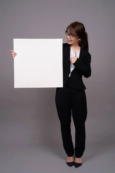 Full length portrait of young Asian businesswoman standing Stock Picture