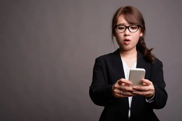 Young beautiful Asian businesswoman using mobile phone — Stock Photo, Image