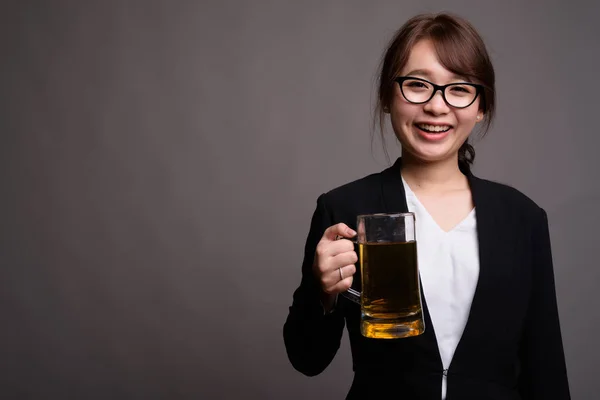 Jonge mooie Aziatische zakenvrouw holding glas bier — Stockfoto