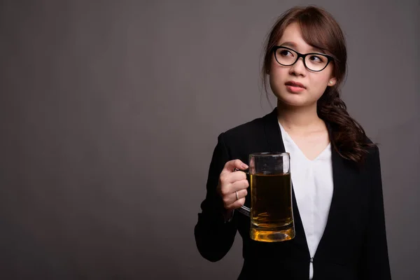 Jeune belle femme d'affaires asiatique tenant un verre de bière — Photo