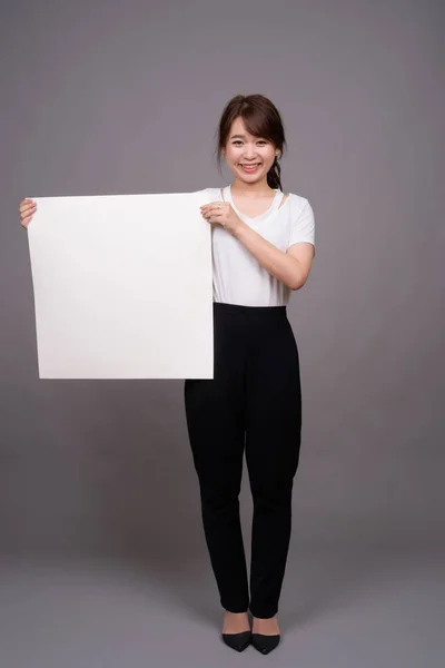Asiatico donna mostrando vuoto bianco bordo con copyspace — Foto Stock