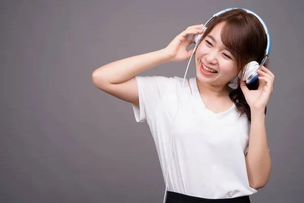 Fiatal gyönyörű ázsiai nő, fárasztó fejhallgató a zene — Stock Fotó