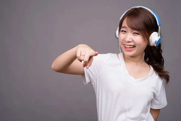 Joven hermosa mujer asiática con auriculares para la música —  Fotos de Stock