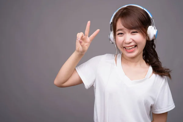 Joven hermosa mujer asiática con auriculares para la música —  Fotos de Stock