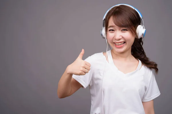 音楽用ヘッドフォンを身に着けている若い美しいアジアの女性 — ストック写真