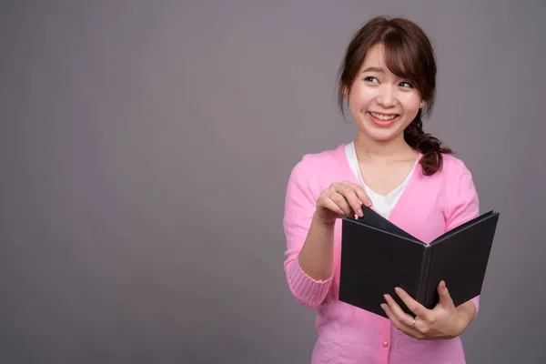 Jonge mooie Aziatische vrouw houden boek of dagboek — Stockfoto