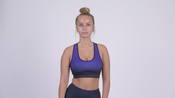 Młody piękny blond Kobieta wskazując na aparat fotograficzny gotowy do siłowni — Wideo stockowe