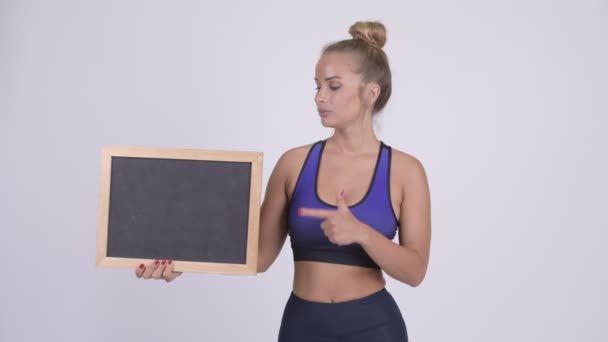 Smutny młoda kobieta blonde holding tablica i daje kciuk w dół — Wideo stockowe