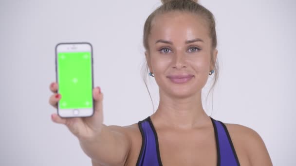 Glücklich junge schöne blonde Frau zeigt Telefon — Stockvideo