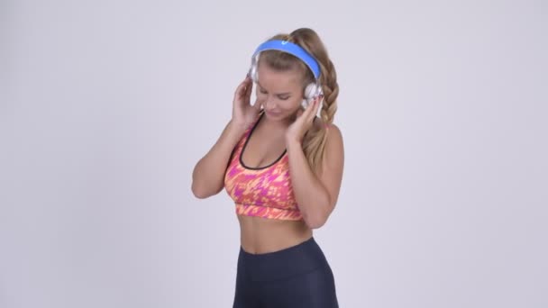 Feliz joven hermosa mujer rubia bailando y escuchando música — Vídeos de Stock