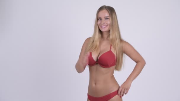 Felice giovane bella donna bionda in bikini dando pollici in su — Video Stock