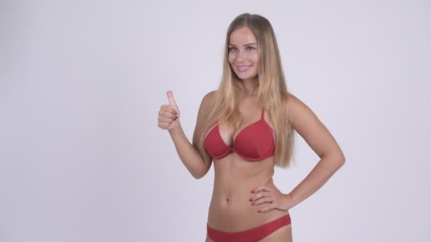 Felice giovane bella donna bionda in bikini dando pollici in su — Video Stock