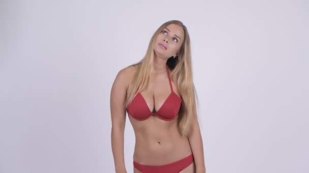 Triest jonge blonde vrouw in bikini duimen neer geven — Stockvideo