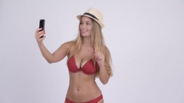 Mutlu genç sarışın turist kadın telefonu ile arama bikini video