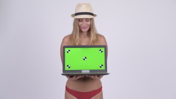 Dizüstü bilgisayarı gösteren ve sürpriz arıyor mutlu genç sarışın turist kadın — Stok video